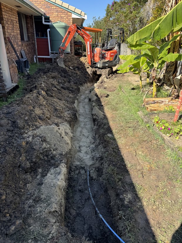 Trench excavated beside a house for an underground leak