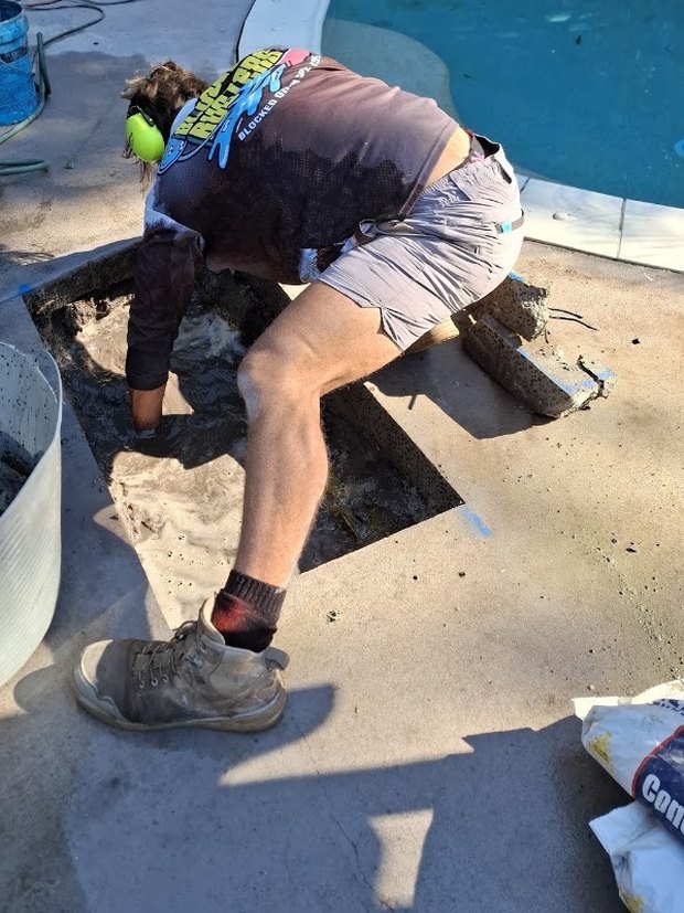 Cutting in to reach a leak beside a pool