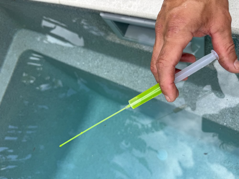 Applying dye to trace a leak around a pool fitting