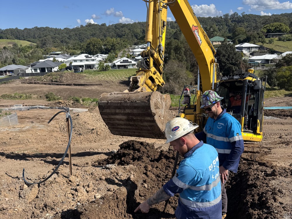 Excavator and crew working a trench on a new estate civil site