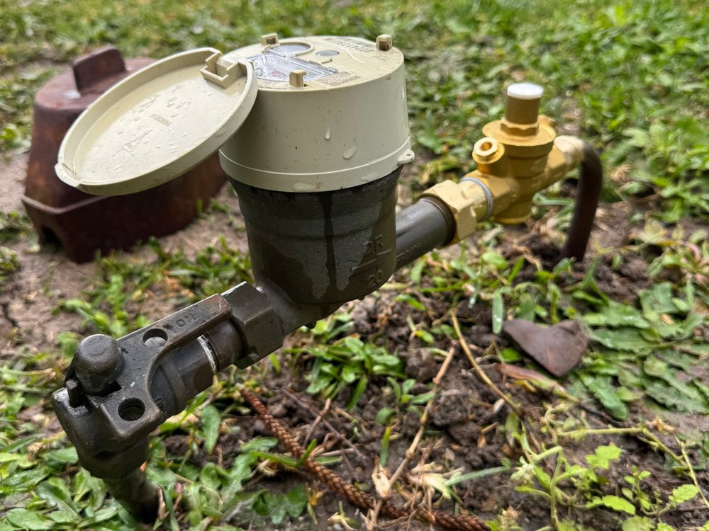 Household water meter with the lid open, ready to check the dial