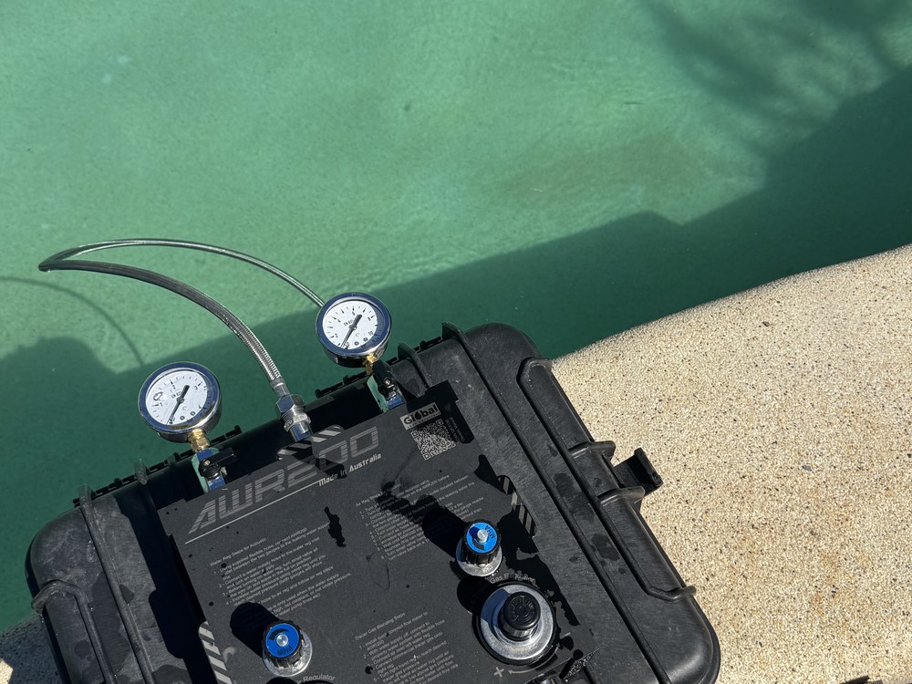 Pressure testing pool plumbing beside a pool