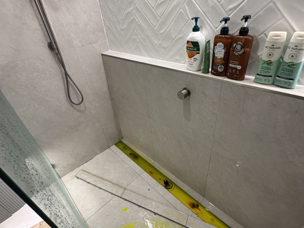 Dye test tracing a leak in a shower base and waste